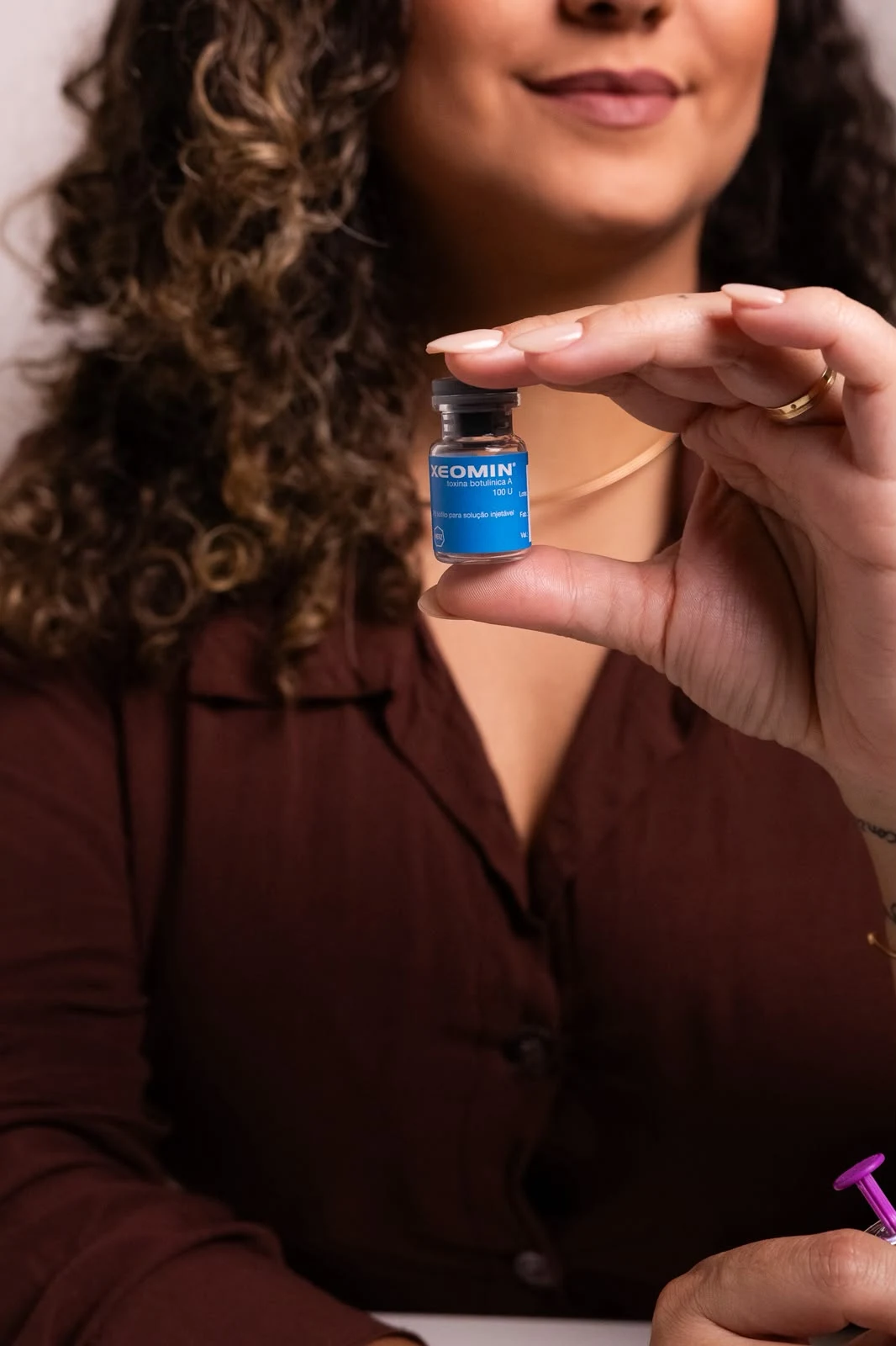 Patrícia Figueiredo segurando um frasco de toxina botulínica